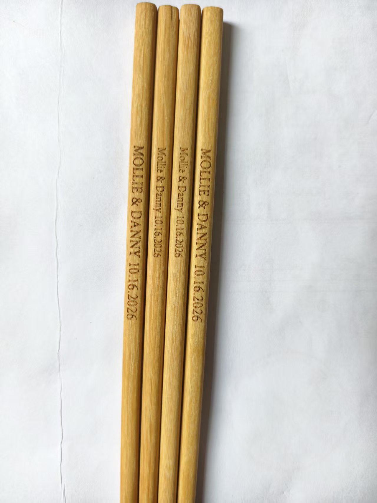 Close-up of names and wedding date engraved into bamboo chopsticks