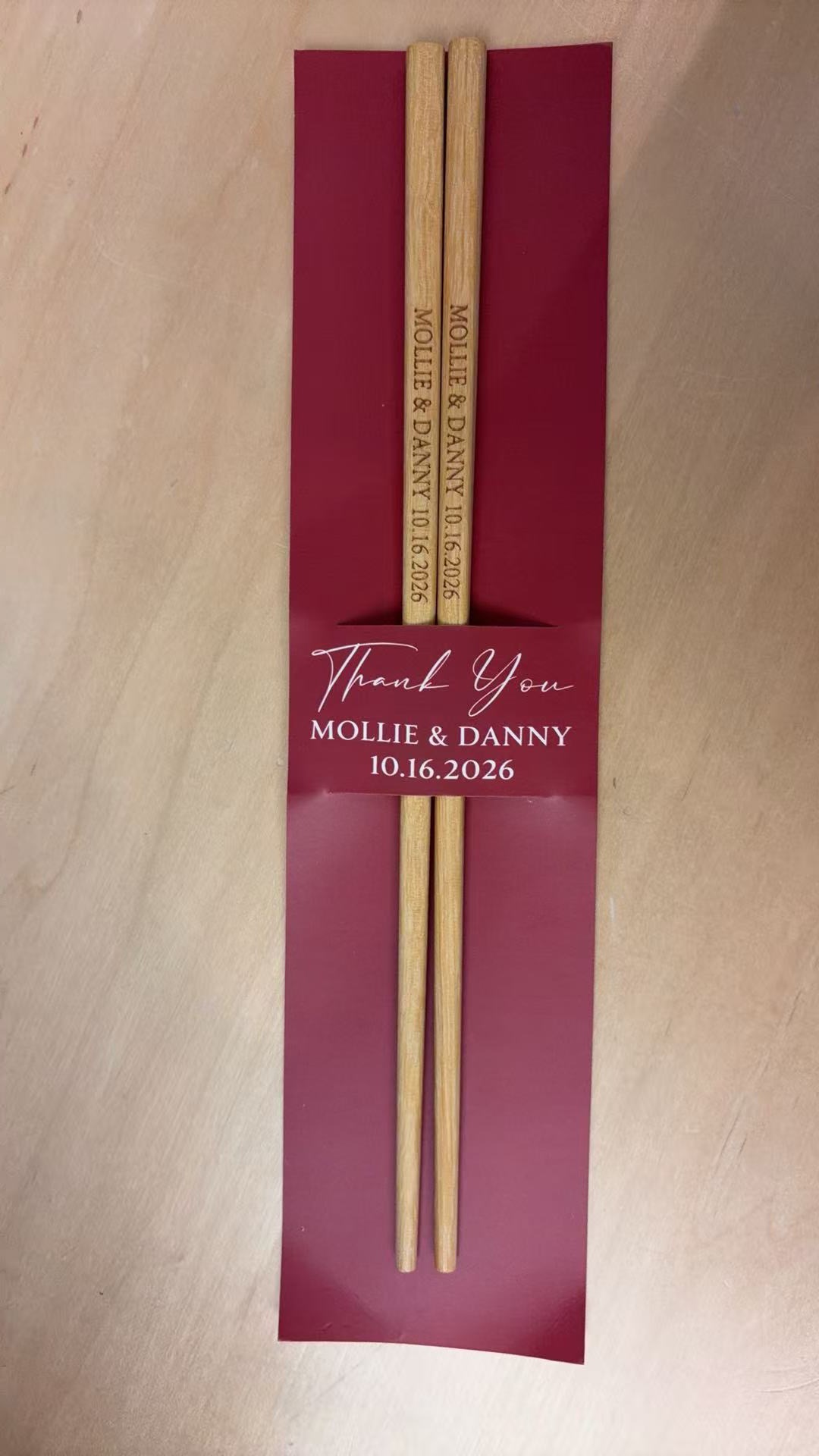 Personalized bamboo wedding chopsticks in a printed paper sleeve